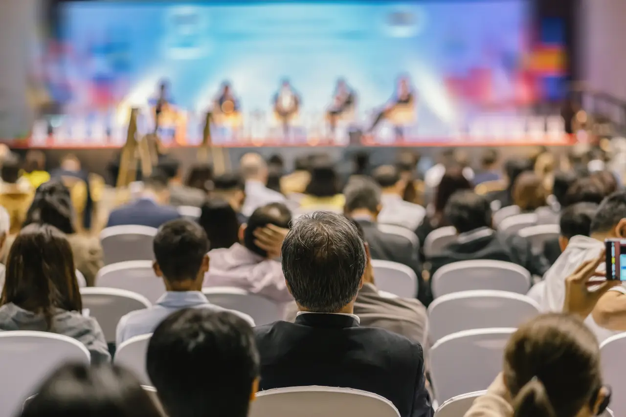 conference-attendees-listening-to-blurred-stage