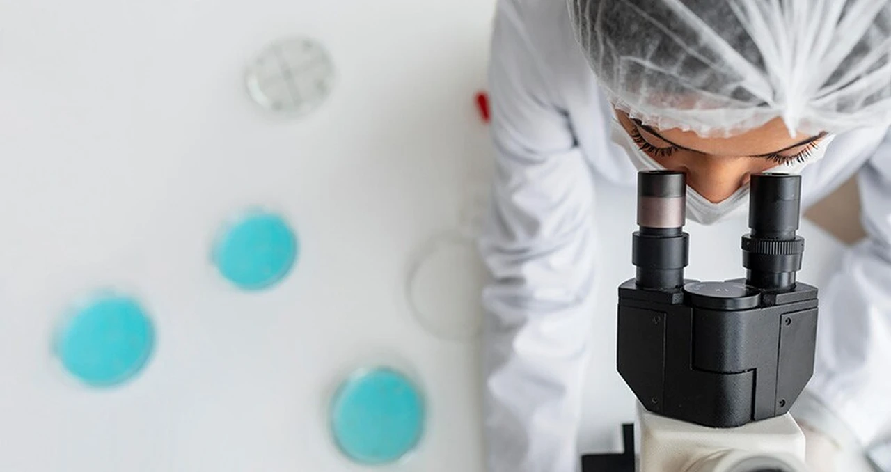 Women with a microscope - image to article Human Genome Research: Is It Now Possible for Scientists to Scale Up and Lead Vaccine Studies?