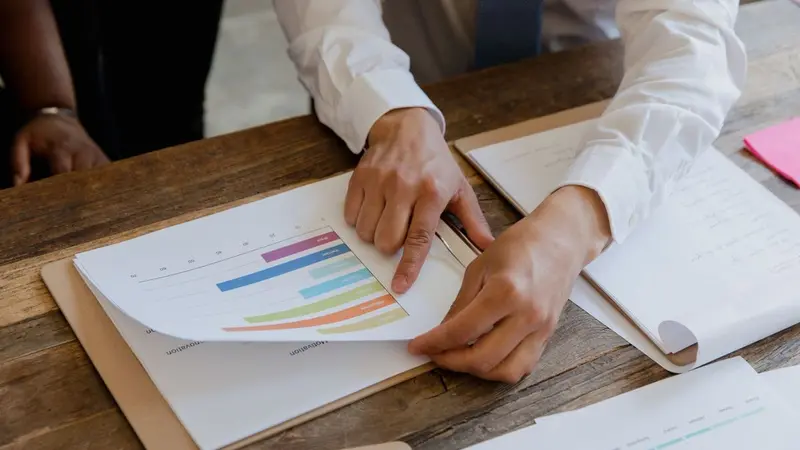 Hands examining colorful charts on a clipboard