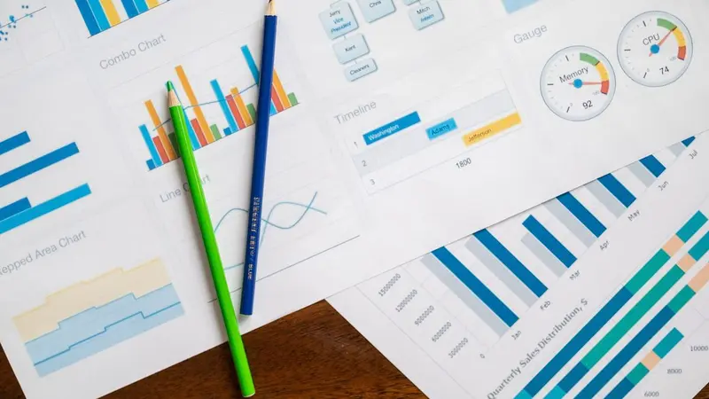 Colorful printed charts with pencils on a desk