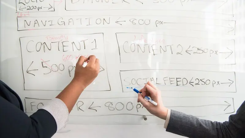 Hand writing content planning notes on a whiteboard
