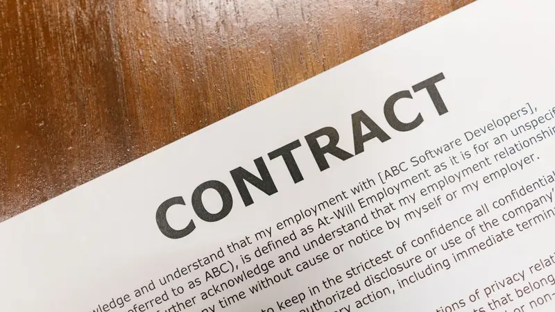 Close-up of a printed contract document on a wooden desk
