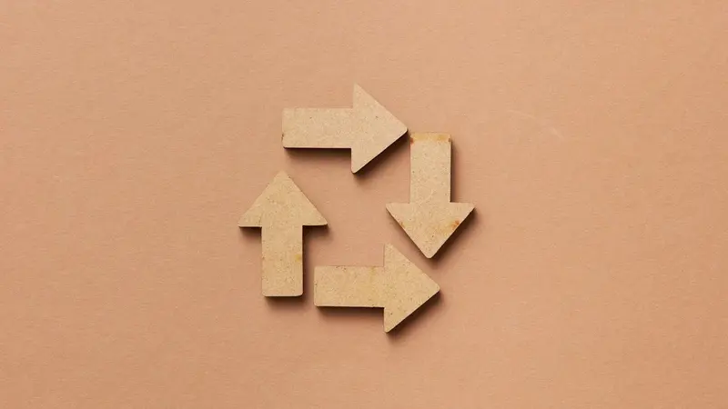 Wooden arrows arranged in a circular loop on a tan background