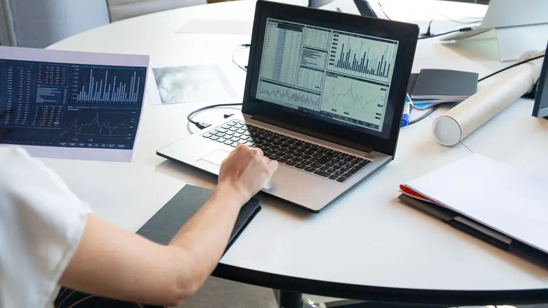 Laptop showing charts on a white table