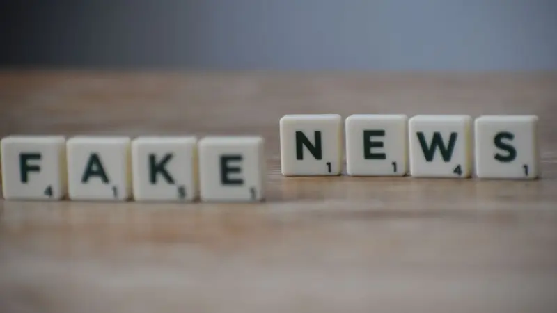 Letter tiles spelling FAKE NEWS on a wooden surface
