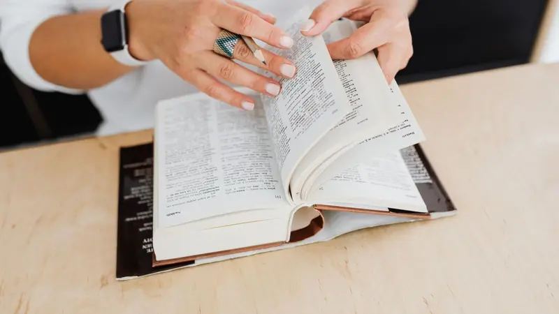 Hands turning the pages of an open book