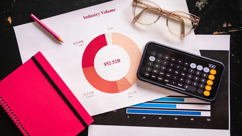 Donut chart, calculator and glasses on a desk, representing budget planning