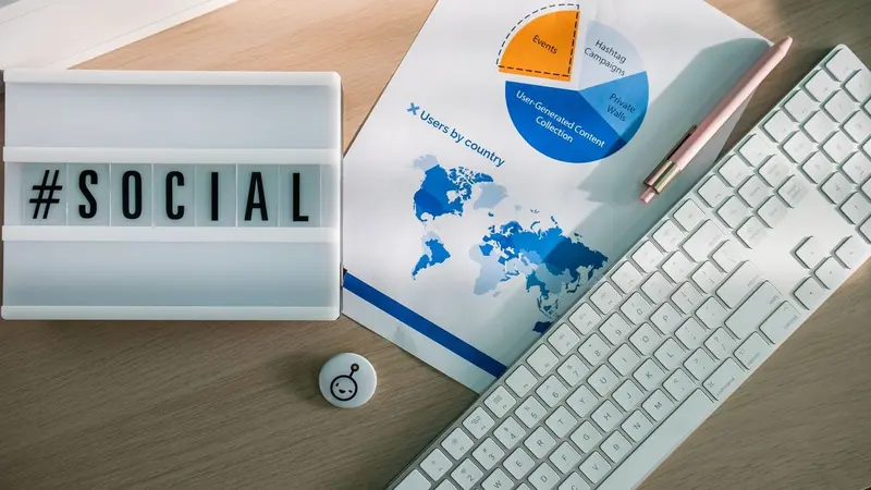 Social sign, keyboard and printed charts on a desk