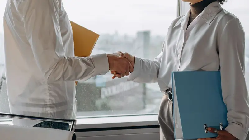 Two business people shaking hands in an office