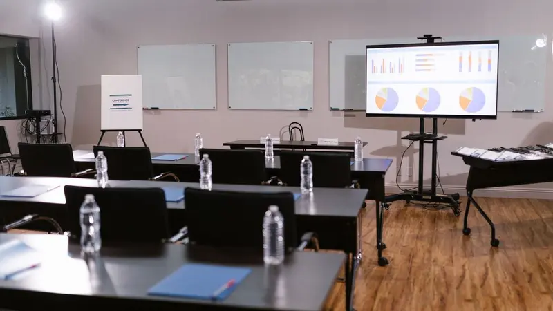 ห้องประชุมจัดโต๊ะ เก้าอี้ และจอโปรเจกเตอร์
