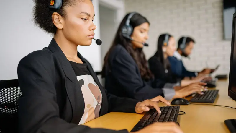 Customer support team wearing headsets working at computers
