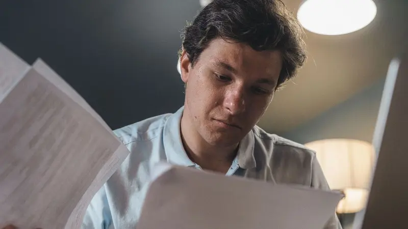 Man reading papers with a thoughtful expression