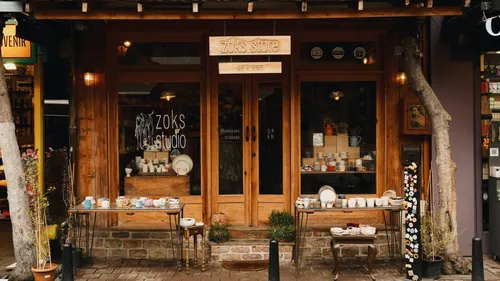 Small cafe storefront with wooden doors and windows on a city street