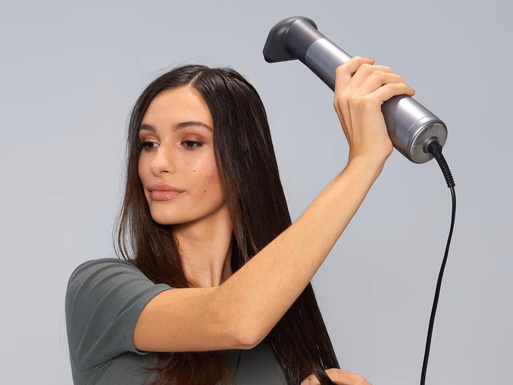 Woman using Braun Air styler to dry and style her hair for a smooth finish.