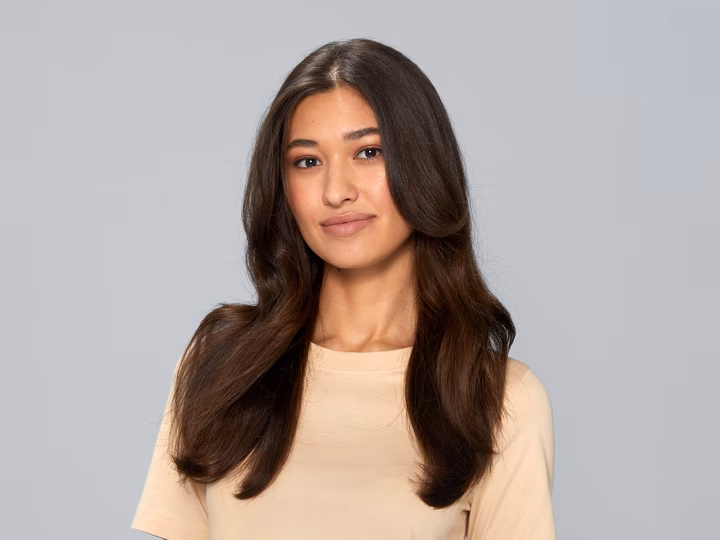 Portrait of woman with shiny, wavy hair after using Braun Air styler.