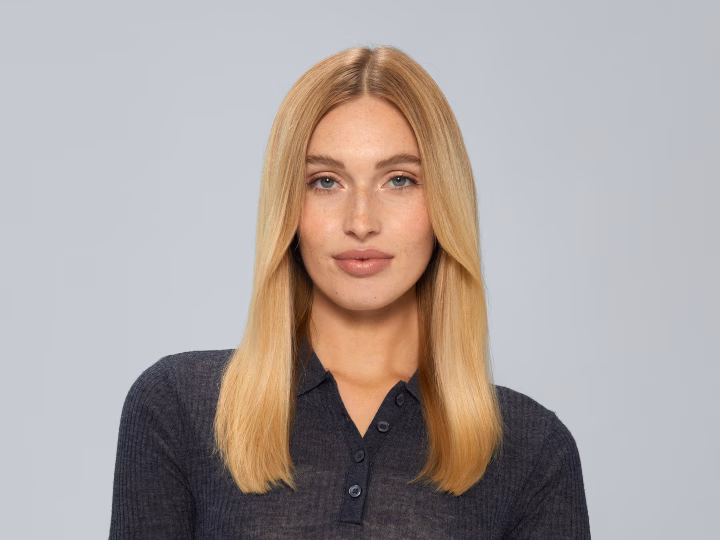 Woman with straight blonde hair styled using Braun HD2.1 Hairdryer, wearing a dark top.