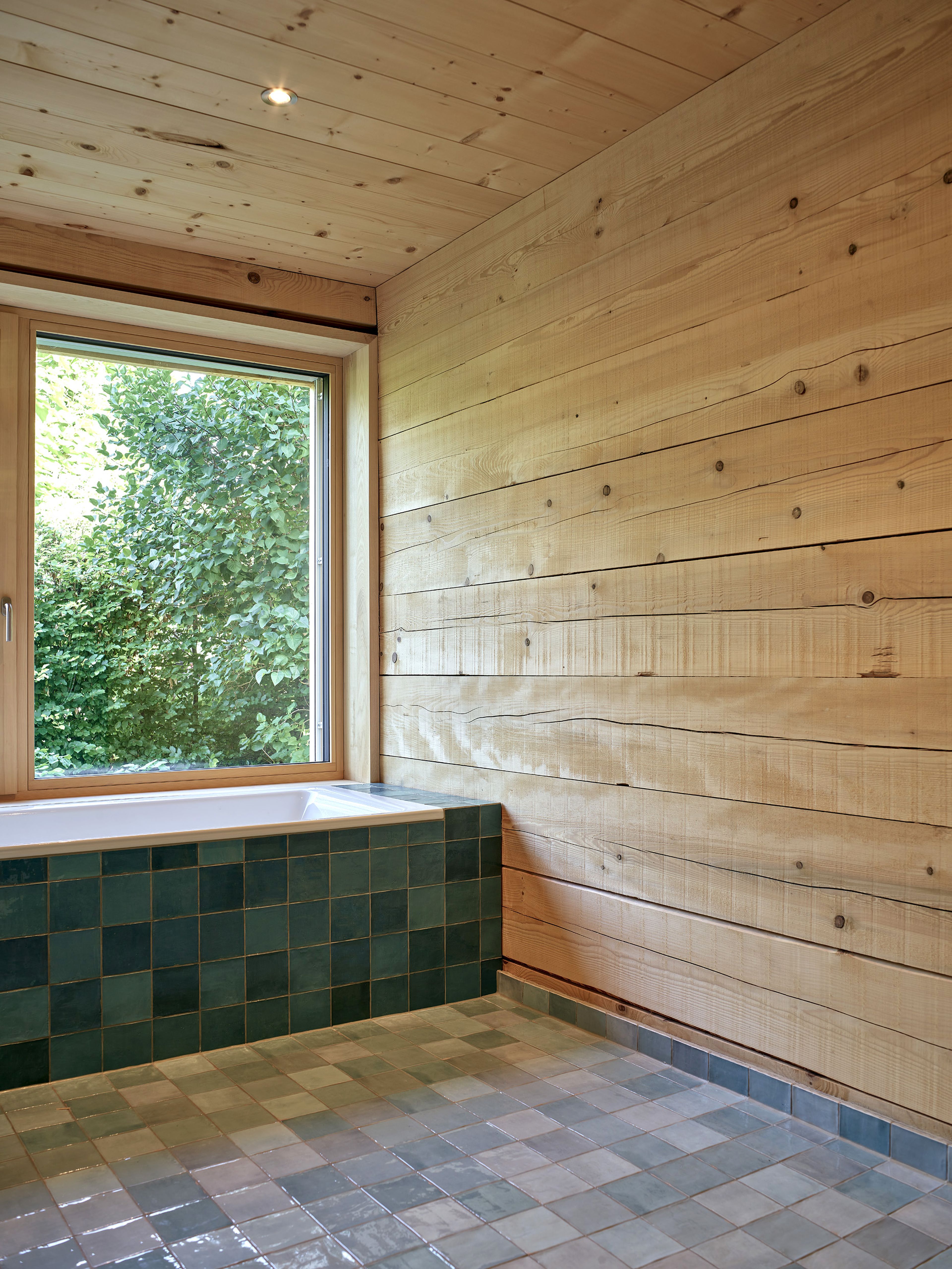 Innenansicht eines Wertvollholzhauses mit sichtbaren massiven Holzbalken, warmem Holzton und gemütlicher, natürlicher Atmosphäre.