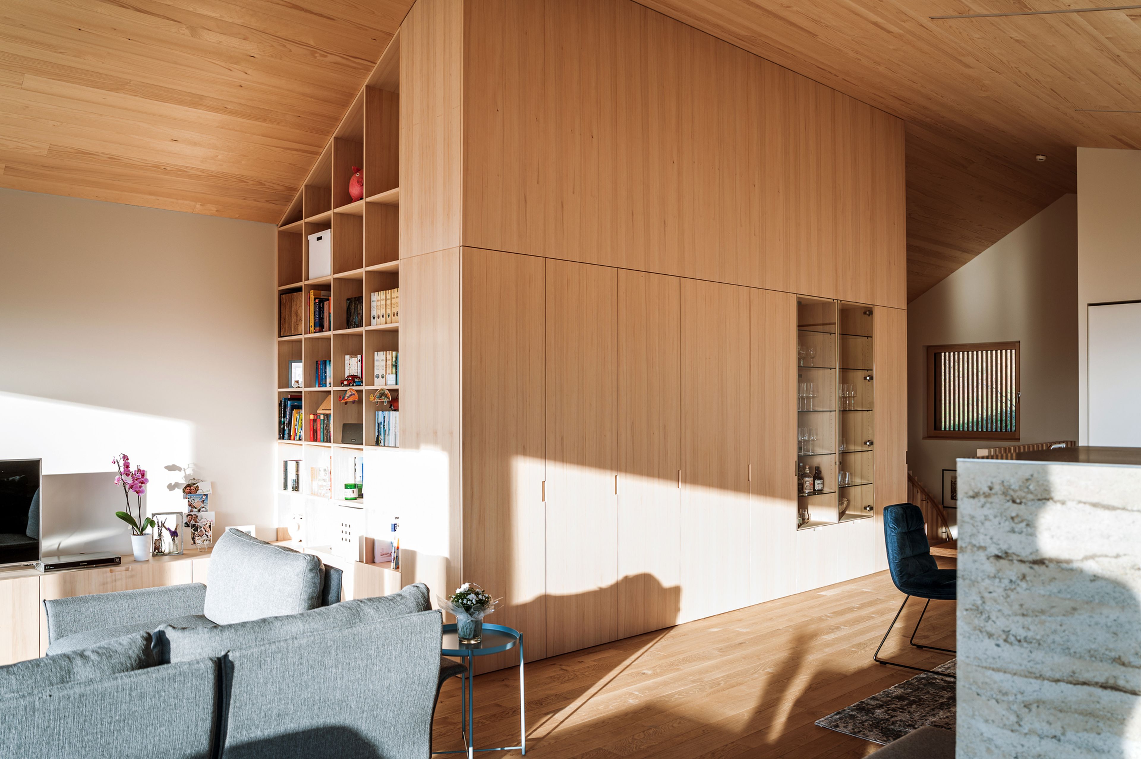 nnenraum eines Einfamilienhaues mit Holzdecke und Innenausbau in Holz und einer handwerklich geprägten Atmosphäre.