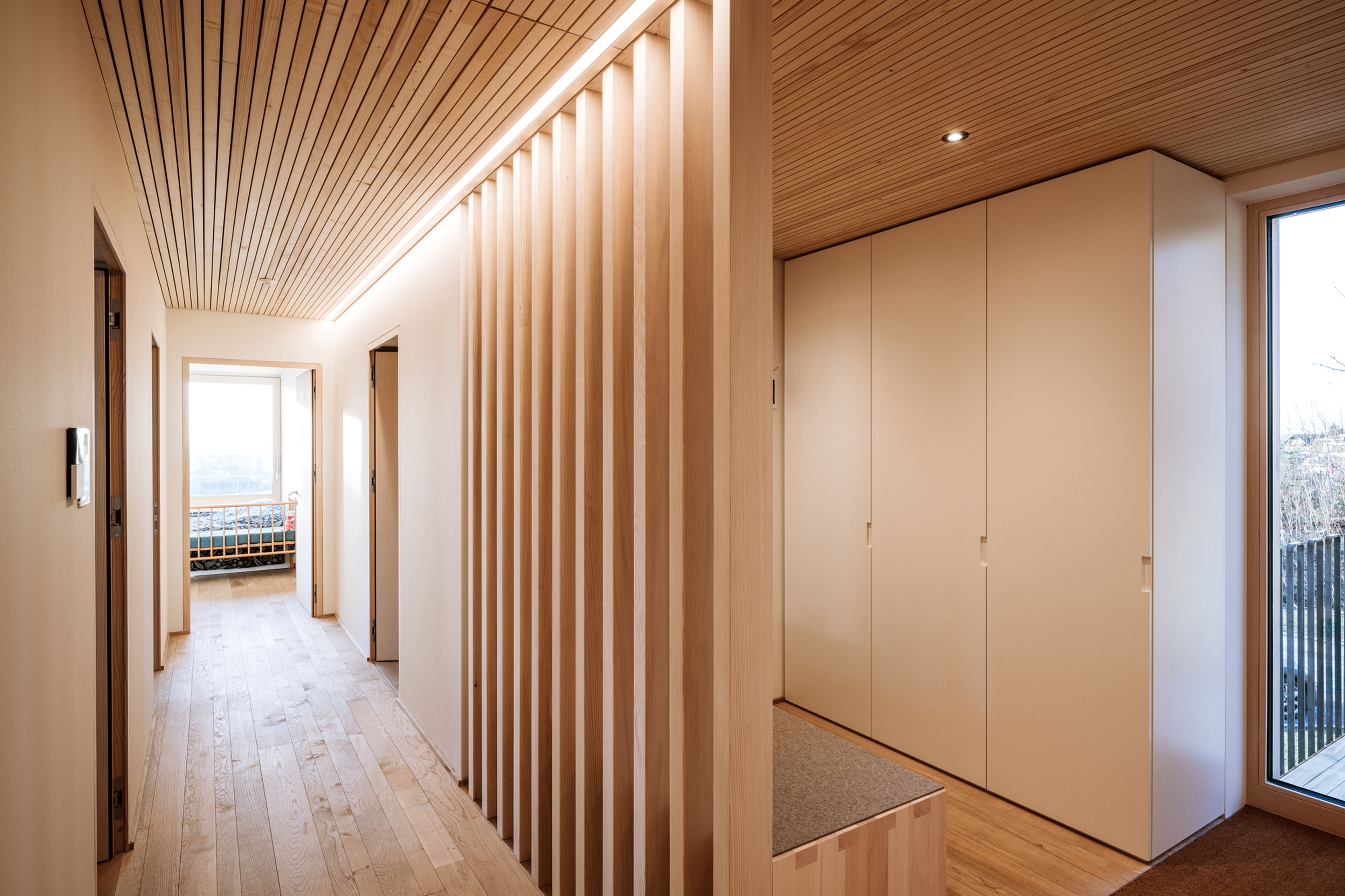 nnenraum eines Einfamilienhaues mit Holzdecke und Innenausbau in Holz und einer handwerklich geprägten Atmosphäre.