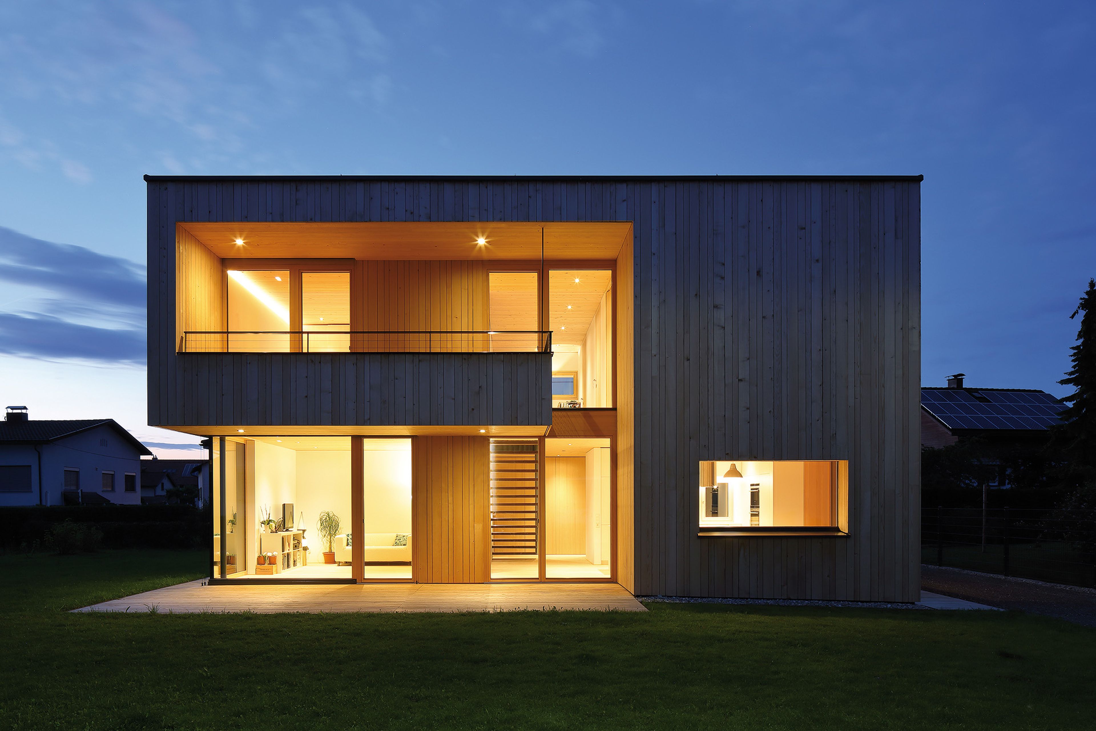 Außenansicht eines Holzhaus mit stehender Holzfassade und moderner, geradliniger Architektur