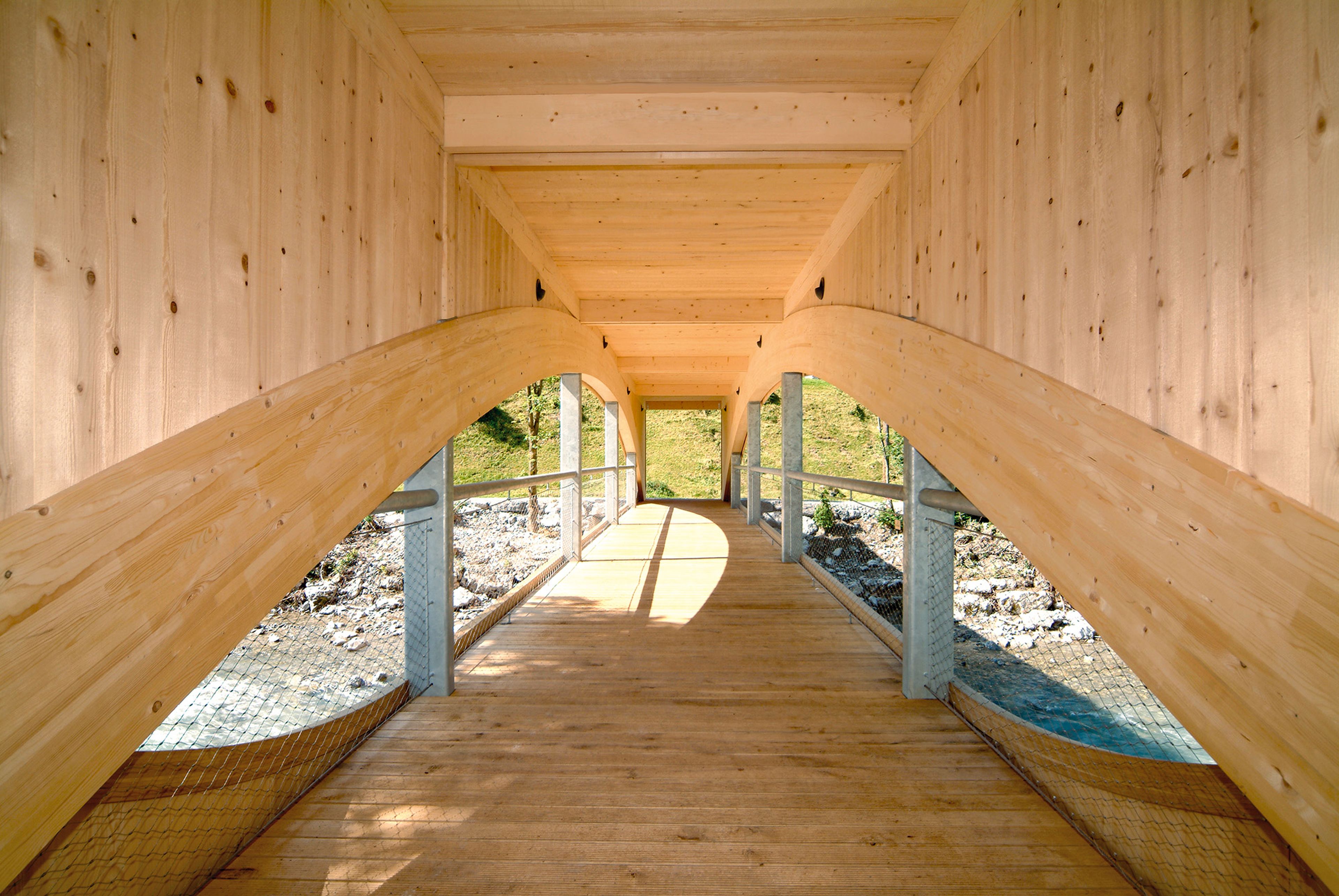 Holzbrücke in Au, Vorarlberg – elegant handgefertigt von der Zimmerei Berchtoldholz: robuste Holzkonstruktion über einem Gewässer, natürliche Holzoberflächen und konstruktive Details im Bregenzerwald-Stil.