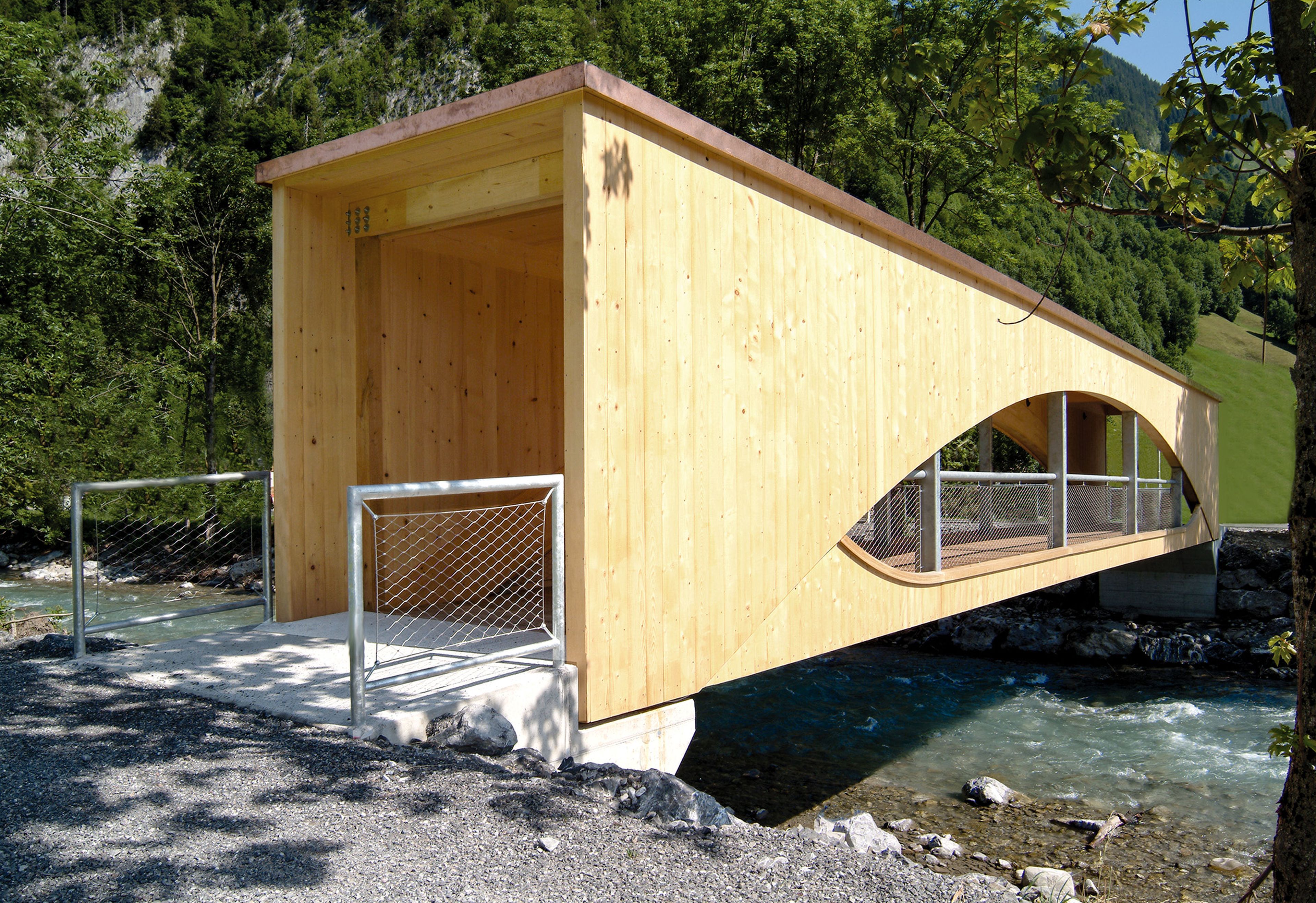 Holzbrücke in Au, Vorarlberg – elegant handgefertigt von der Zimmerei Berchtoldholz: robuste Holzkonstruktion über einem Gewässer, natürliche Holzoberflächen und konstruktive Details im Bregenzerwald-Stil.