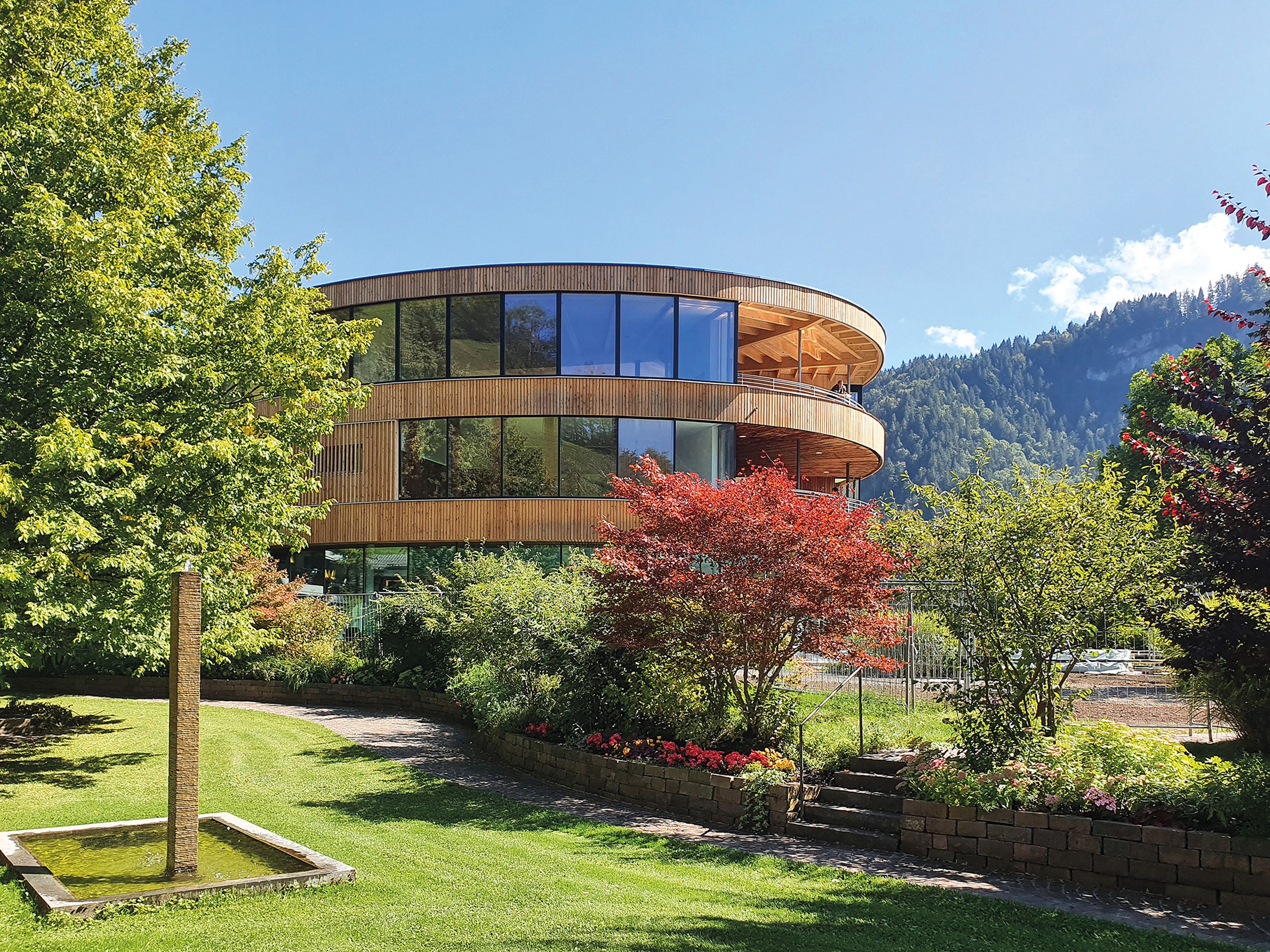 Aussenansicht Gesundhotel Bad Reuthe - Holzkonstruktion mit Holzfassade und großen Fensterflächen, rundum eine schöne Gartenanlage