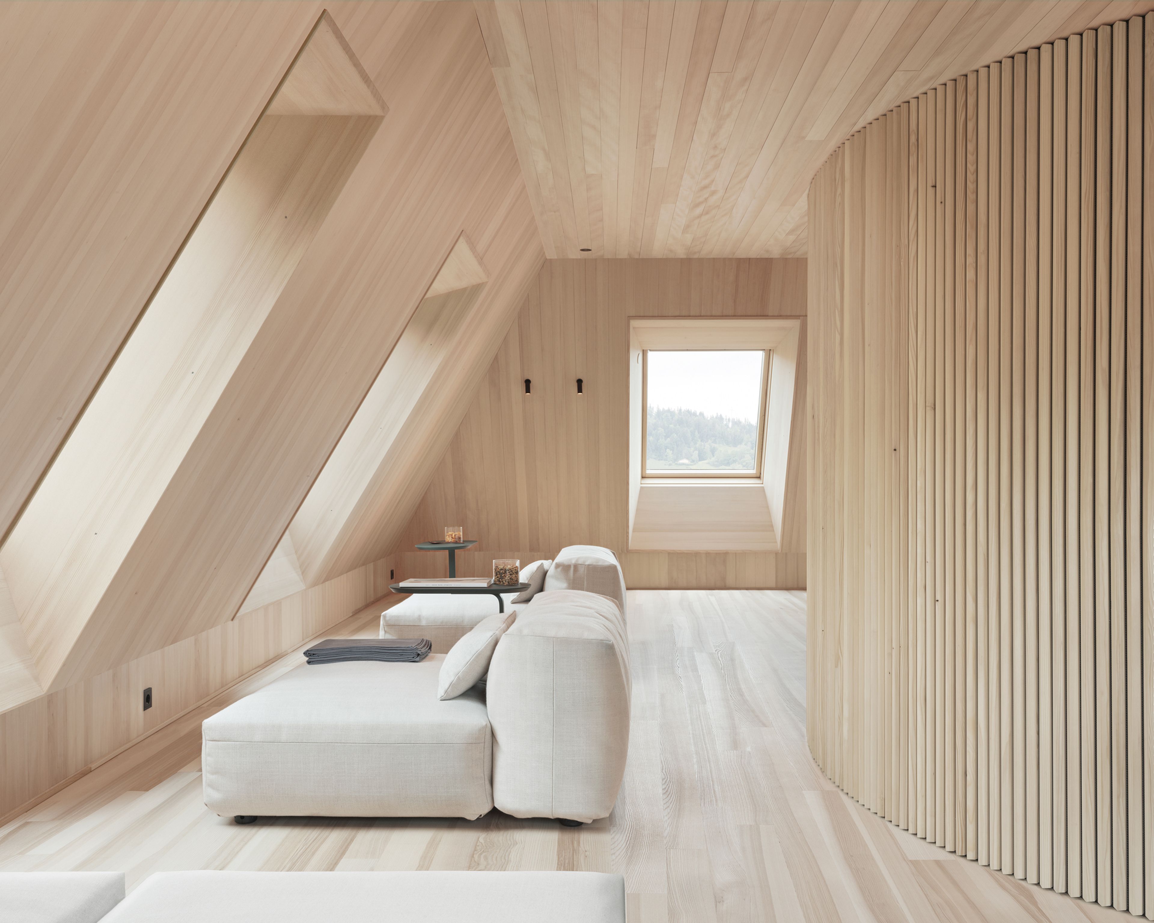 Badehaus des Hotel Hirschen in Schwarzenberg: helles Holzgebäude mit dunklem Dach und Außenpool in einem Garten, Teil des Spa-Bereichs des Hotels.