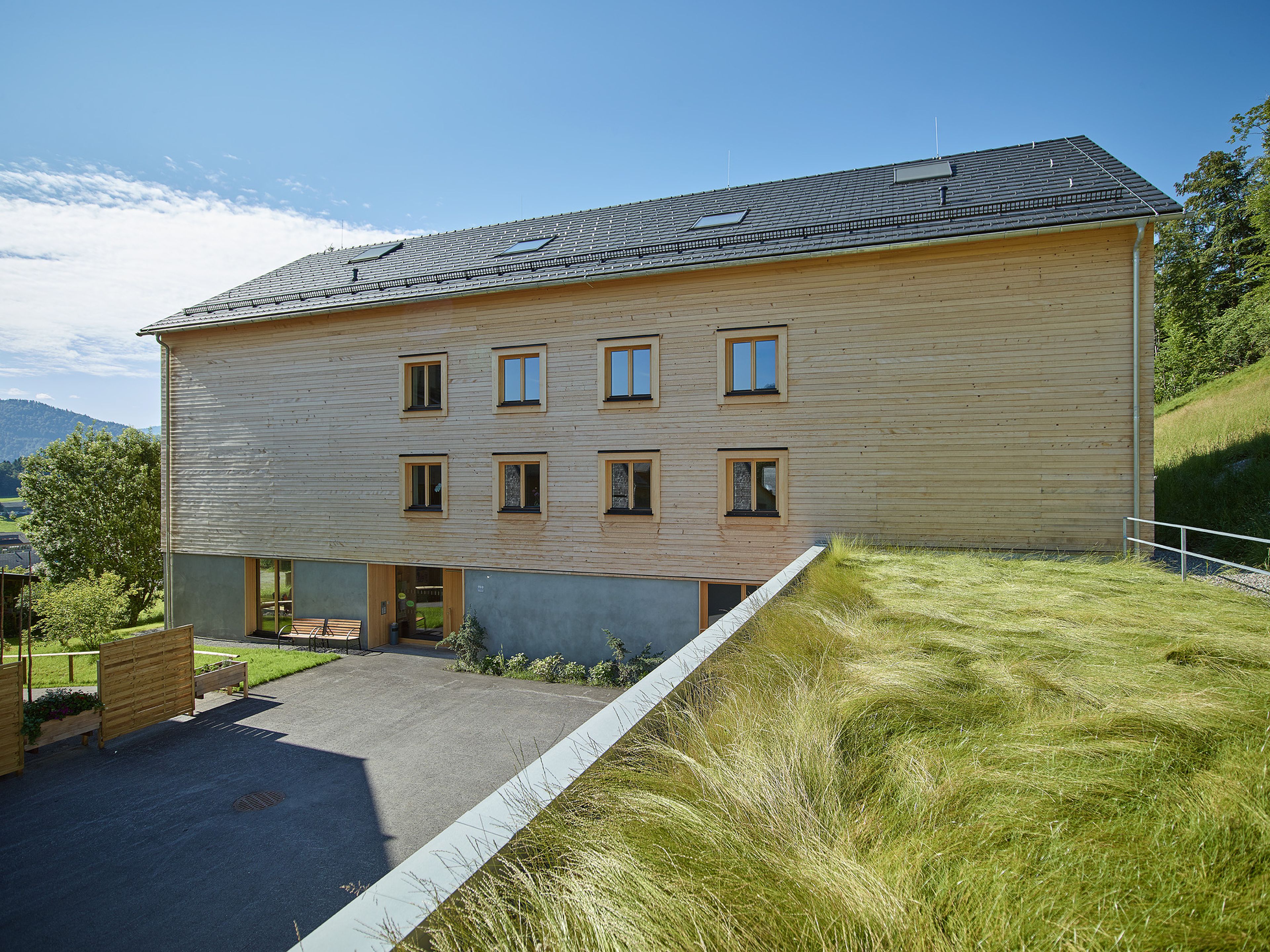Mehrgeschossiger Holzbau Betreutes Wohnen Schwarzenberg mit moderner Architektur, Holzfassade und Satteldach.