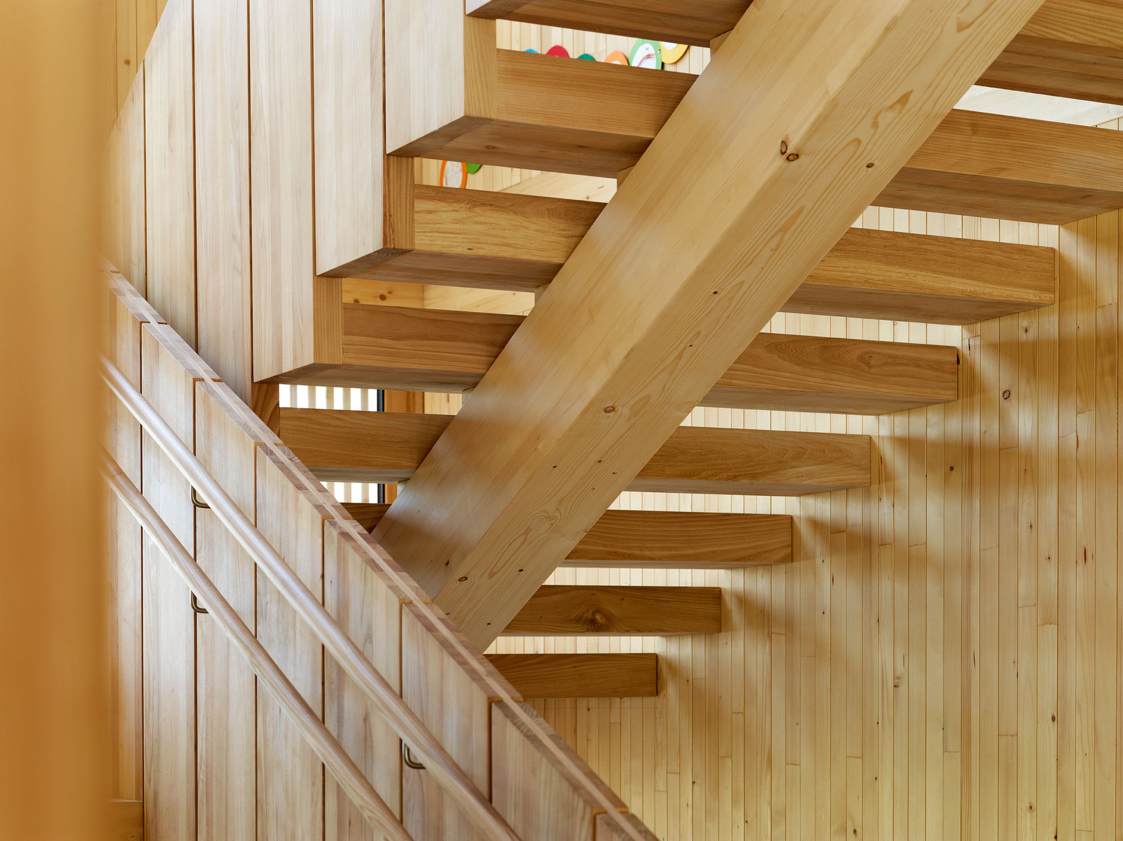 Detailaufnahme einer Holzstiege eines Kindergartens in moderner Holzbauweise.