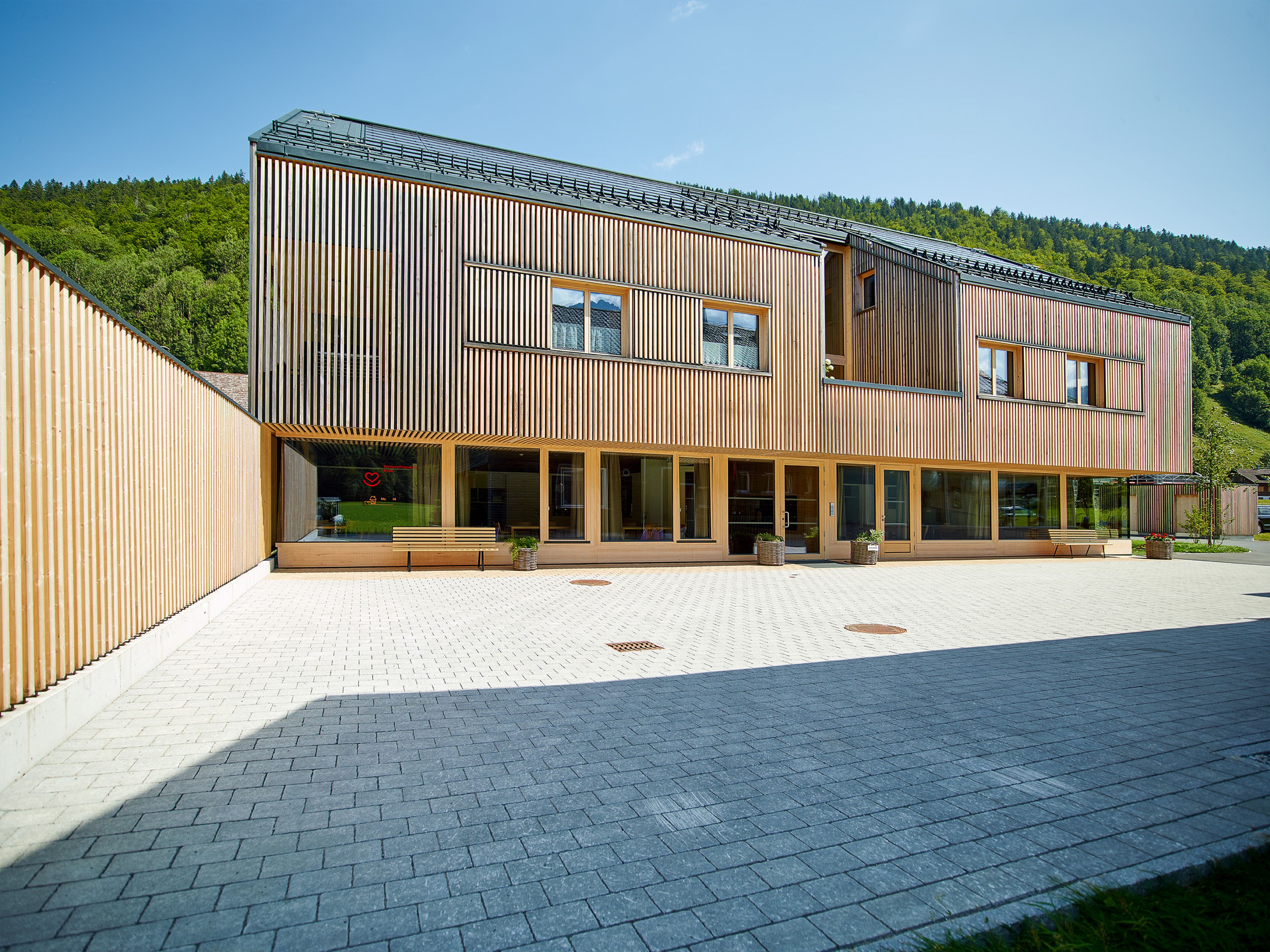 Mehrgeschossiger Holzbau Betreutes Wohnen in Bizau mit moderner Architektur, Holzfassade und Satteldach.