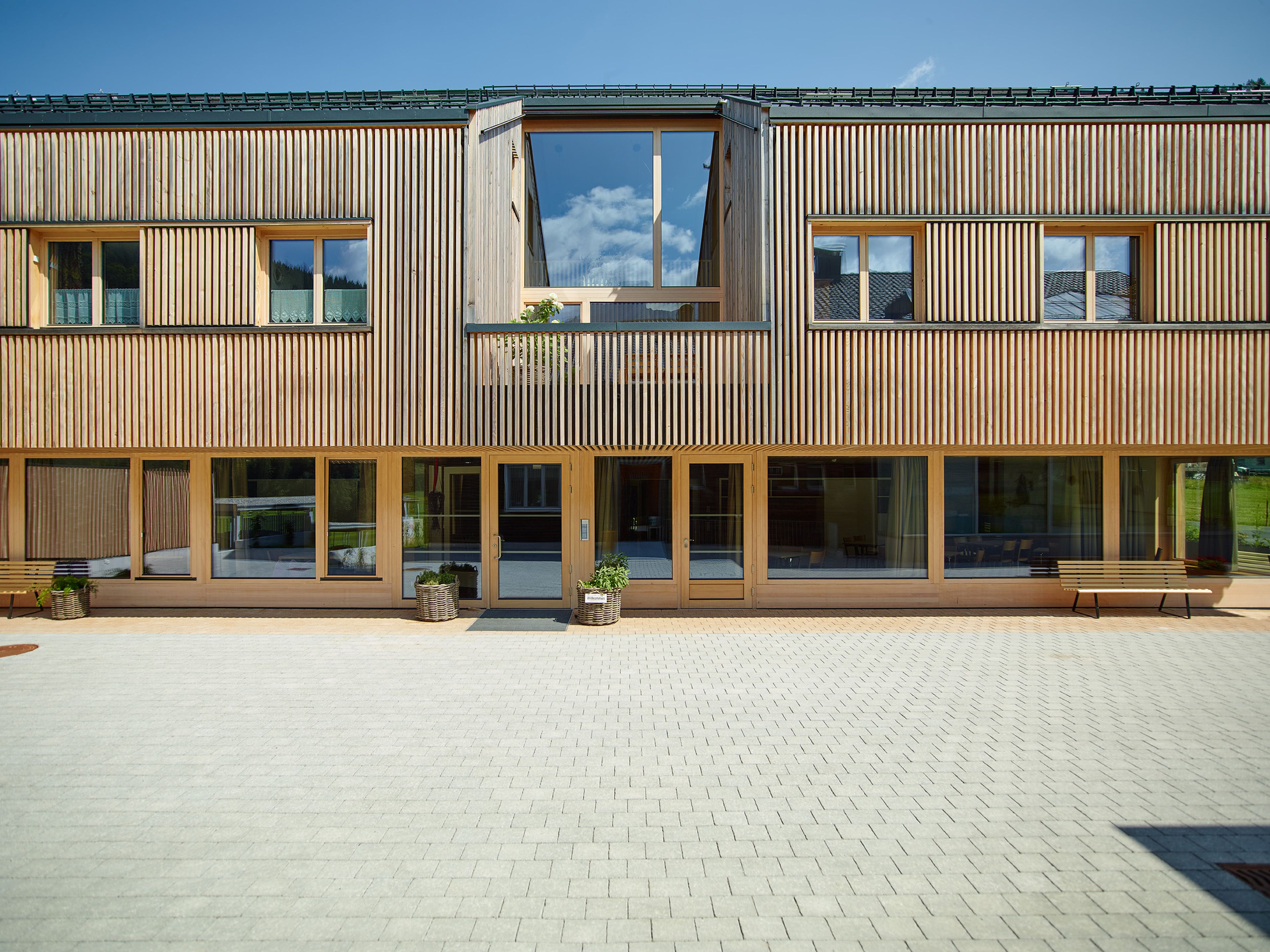 Mehrgeschossiger Holzbau Betreutes Wohnen in Bizau mit moderner Architektur, Holzfassade und Satteldach.
