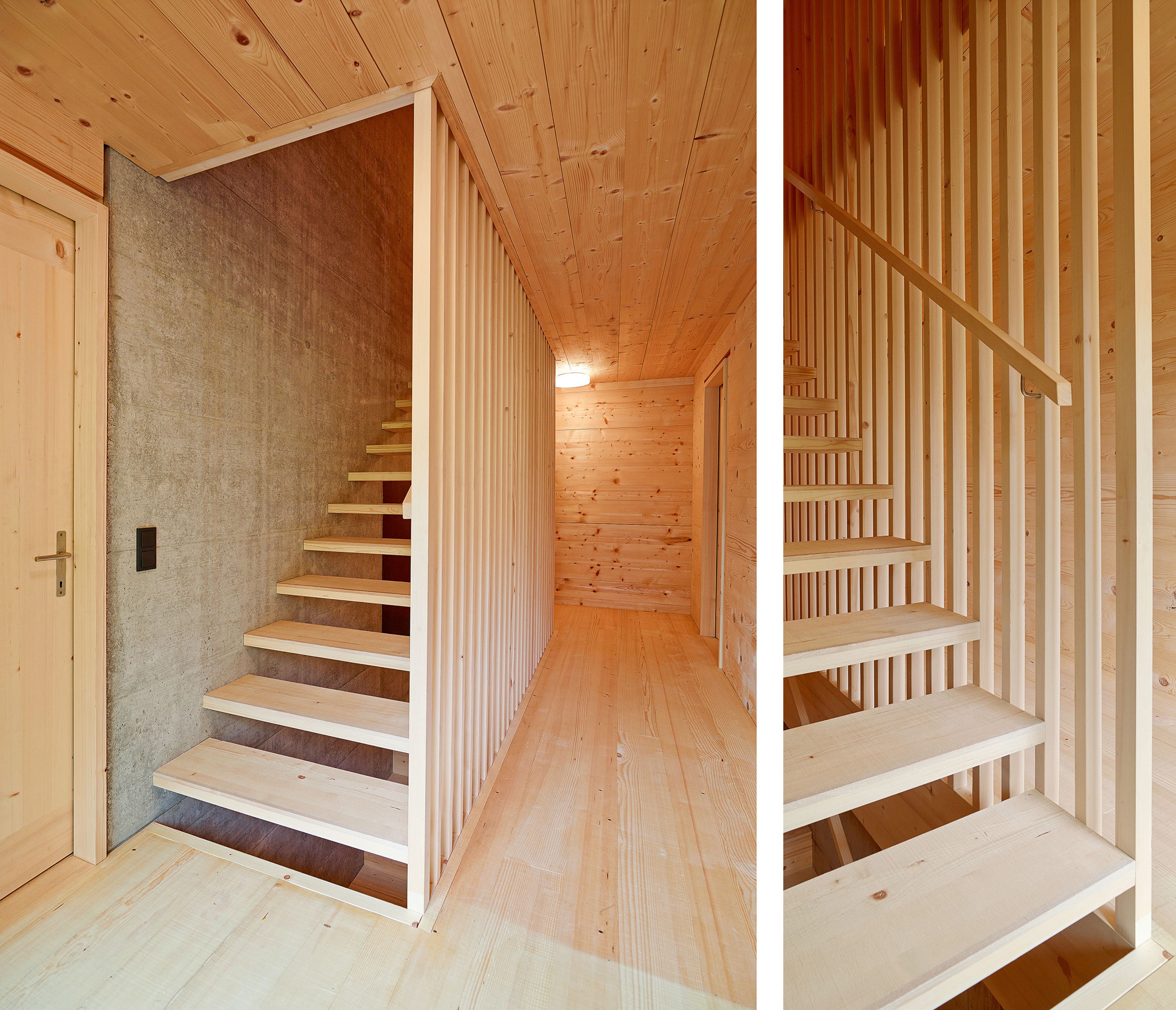 Holztreppe / Holzstiege mit offenen Stufen und Holzgeländer, abgegrenzt vom Raum mit offenen Holzlamellen