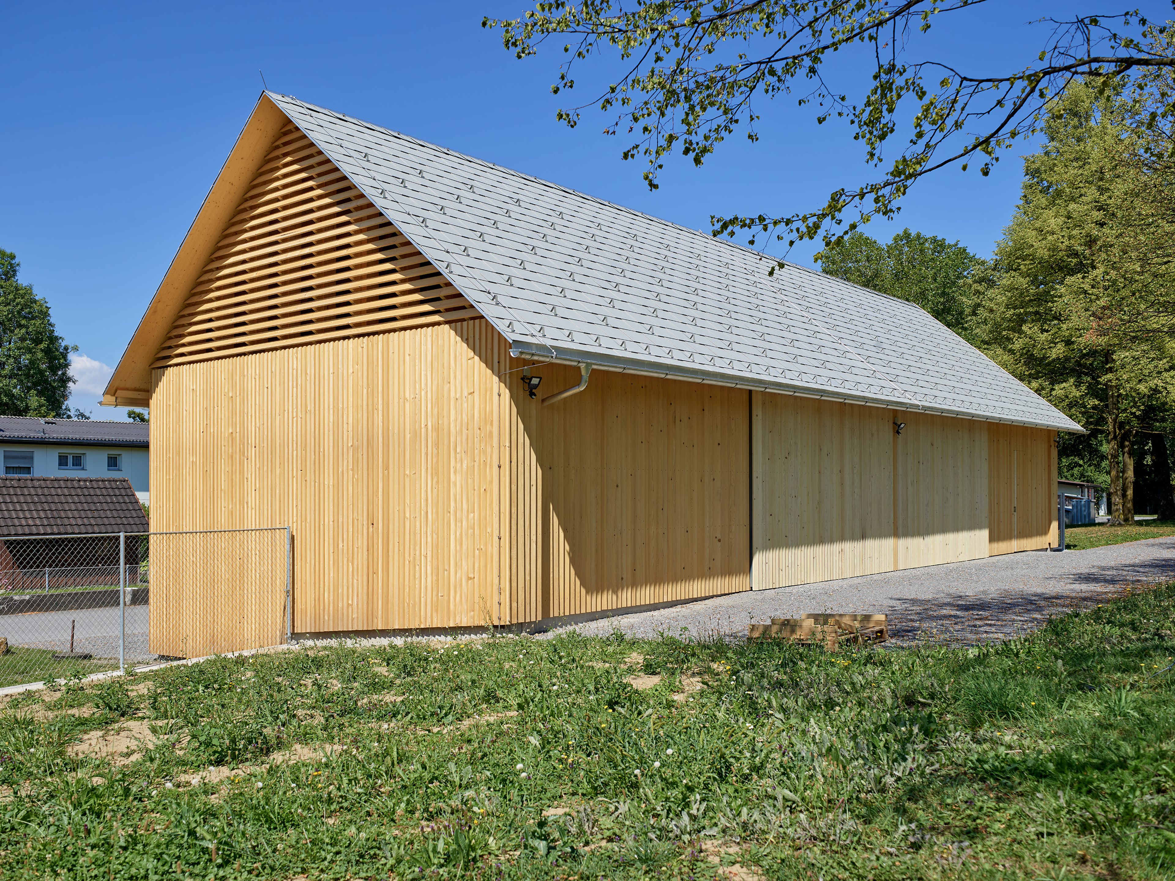 Außenansicht der Gerätehalle in der Birkenwiese Dornbirn, geradlinige Architektur mit Holzfassade und Satteldach.