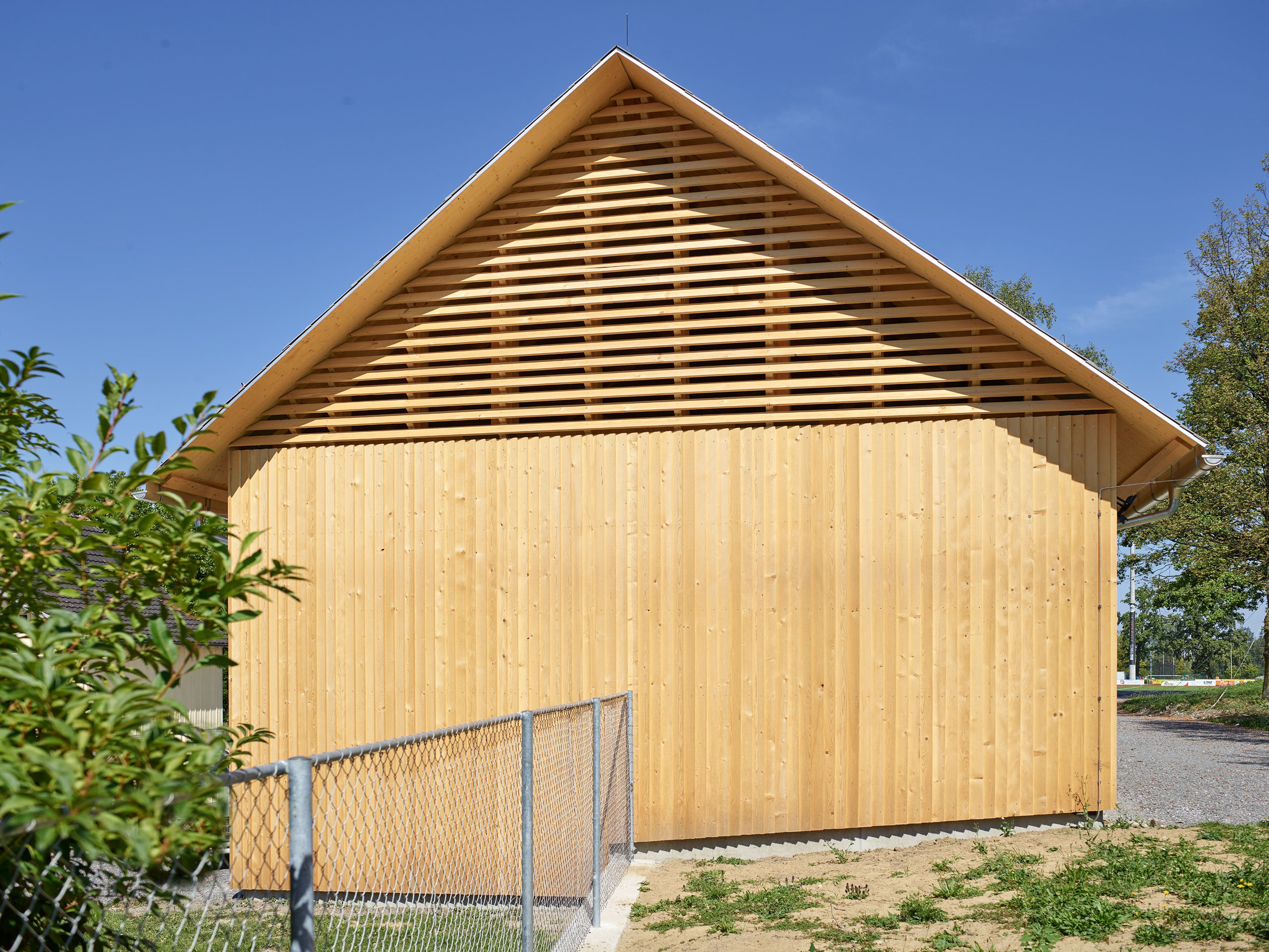 Außenansicht der Gerätehalle in der Birkenwiese Dornbirn, geradlinige Architektur mit Holzfassade und Satteldach.