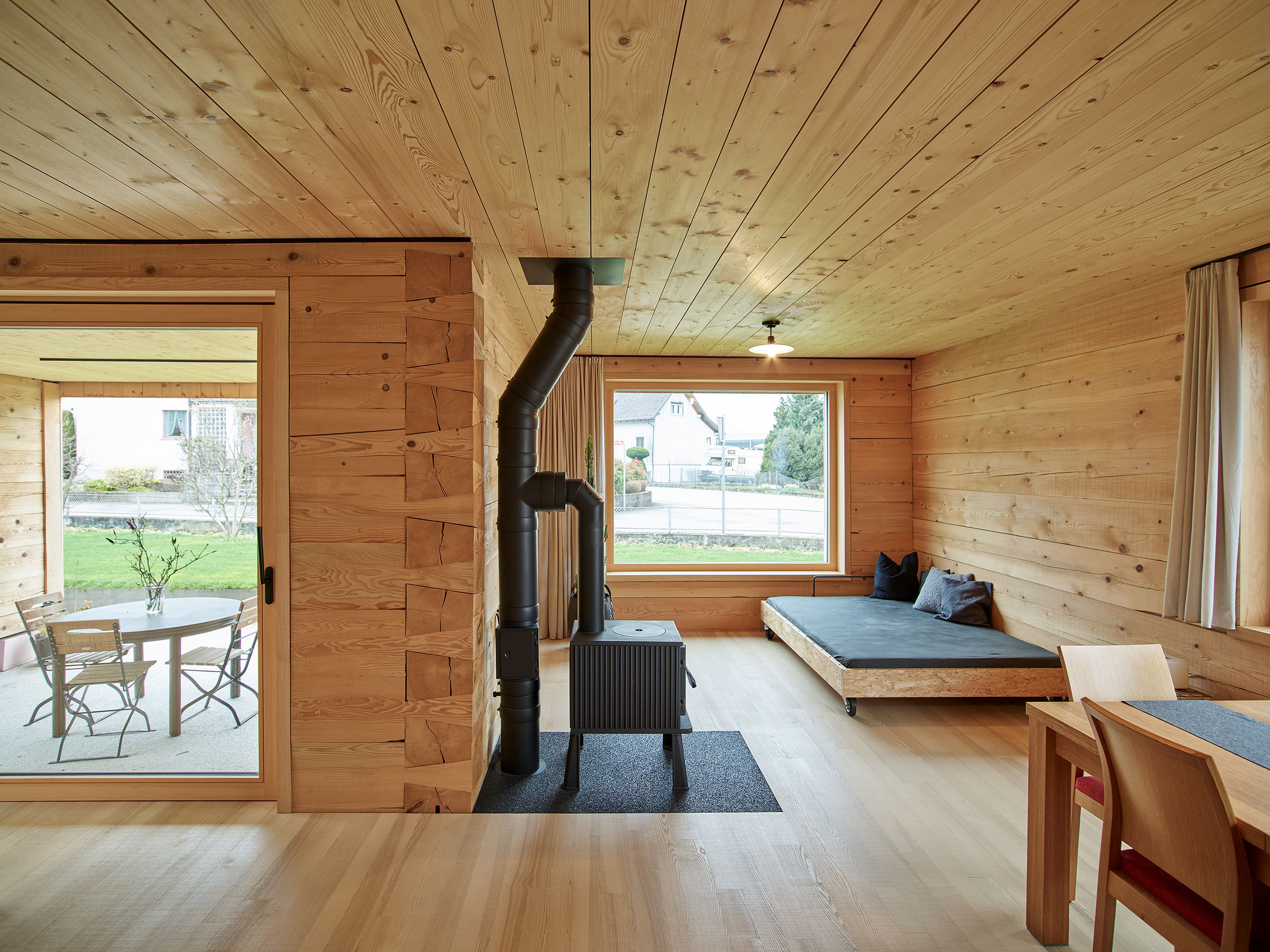 nnenraum eines Holzhauses in gestrickter, massiver Bauweise mit warmem Naturlicht und einer ruhigen, handwerklich geprägten Atmosphäre.