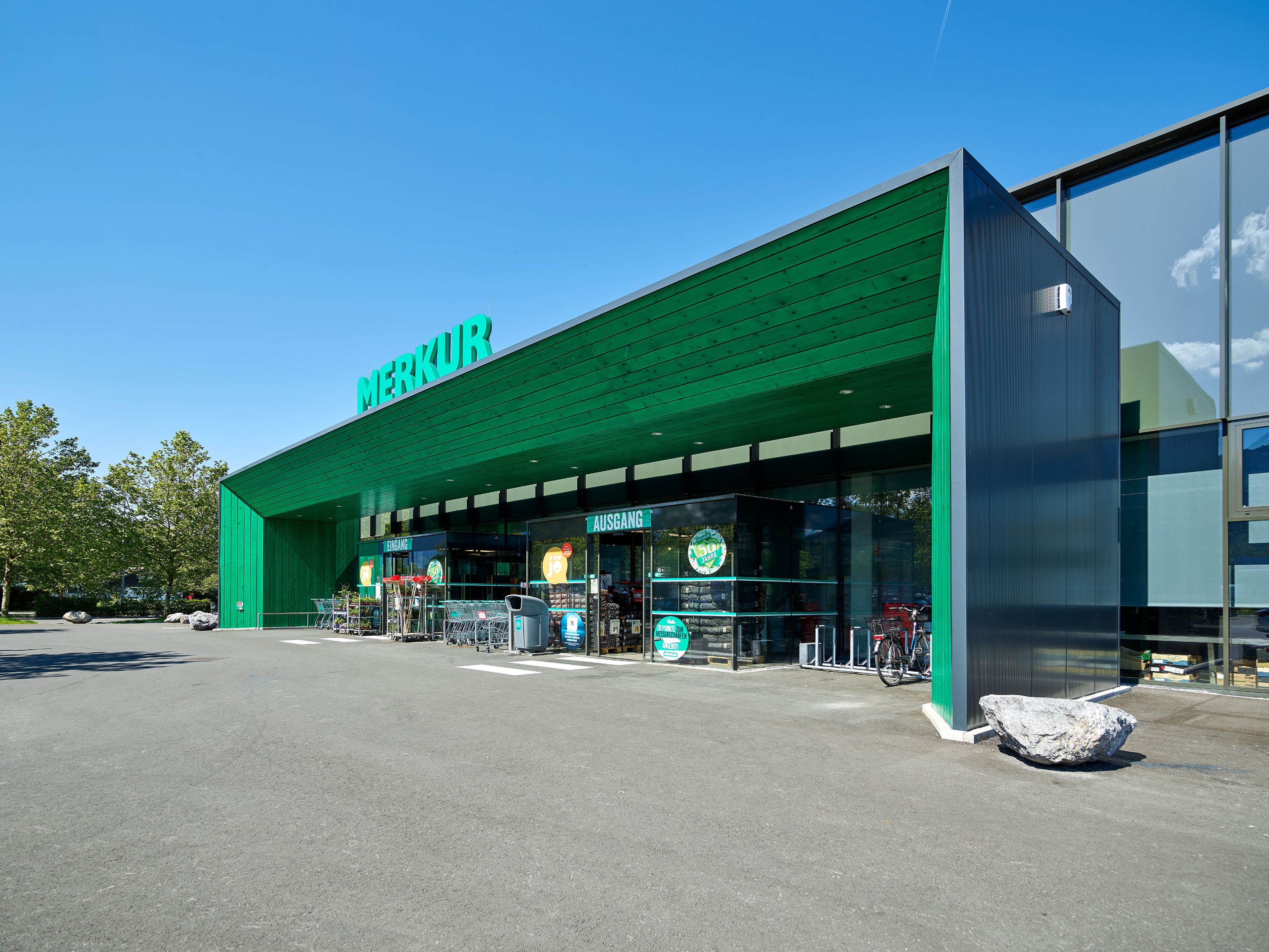 Holzkonstruktion Lebensmittelgeschäft Merkur Dornbirn mit grün lasiertem Holz