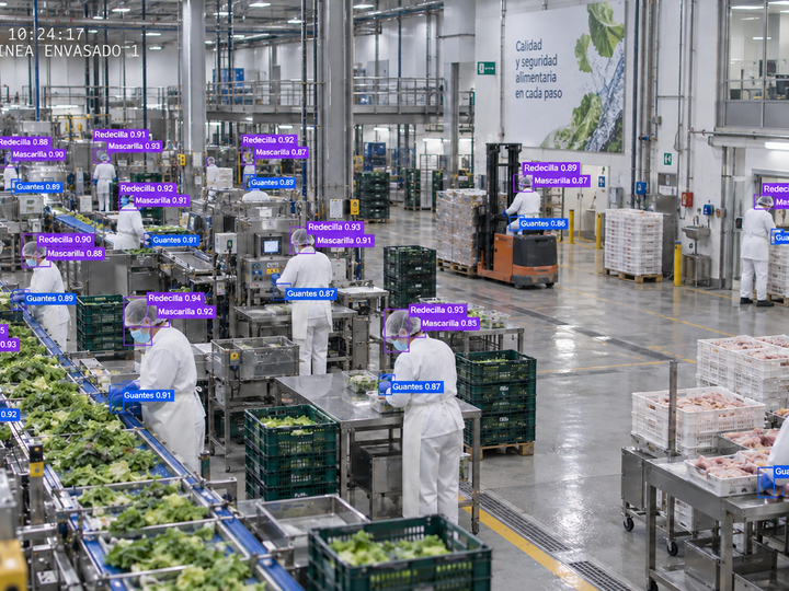 Operarios con bata y redecilla en una planta alimentaria, con EPIs detectados por la IA