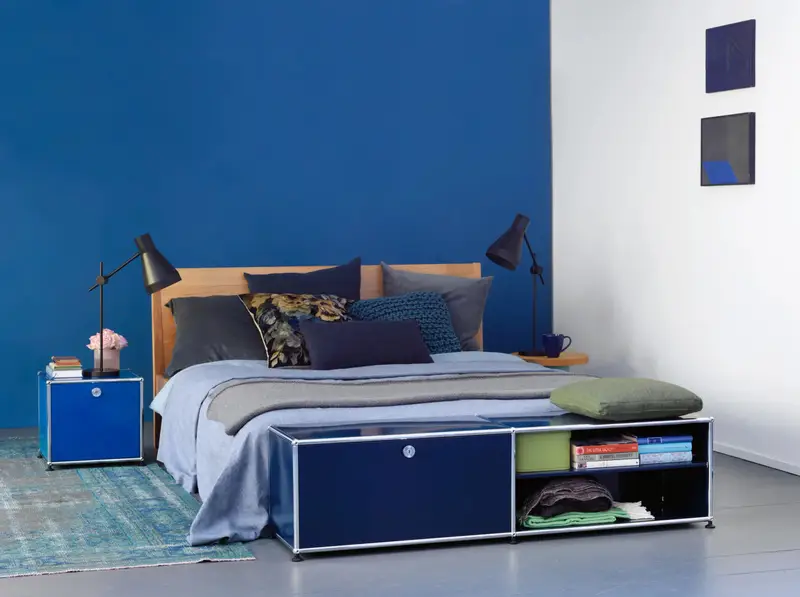 USM Haller Lowboard genutzt als Betttruhe an einem Bett.