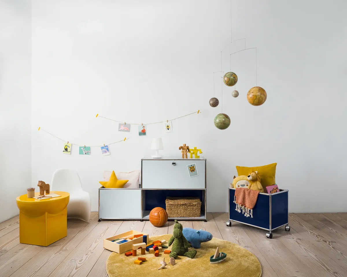 USM Haller Sideboard und Rollcontainer mit offenen Fächer für genug Stauraum. Befüllt mit Kinderspielzeug.