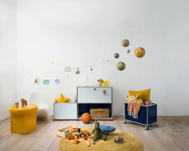USM Haller Sideboard und Rollcontainer mit offenen Fächer für genug Stauraum. Befüllt mit Kinderspielzeug.
