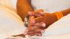 Advaita Master Madhukar’s hands folded in his lap, symbolizing humble service to those who seek freedom.