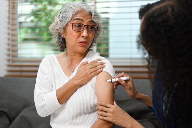 Patient receiving injection administration training from nurse