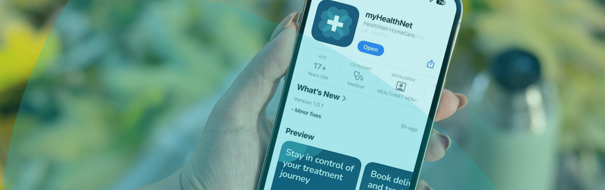 Person holding a smartphone displaying the myHealthNet app page with options to open or update the app.