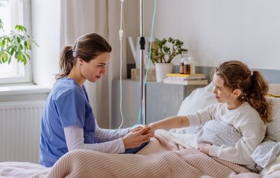 Nurse assists child during treatment at home