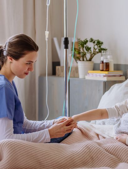 Nurse assists child during treatment at home