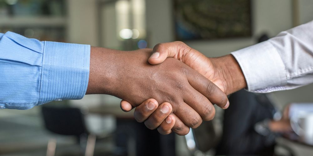 Two people are shaking hands signifying an agreement or partnership.