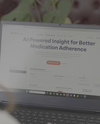 Person using a laptop displaying a webpage about AI-powered insights for better medication adherence.