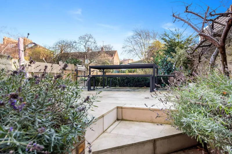 Raised stone terrace with pergola and planting
