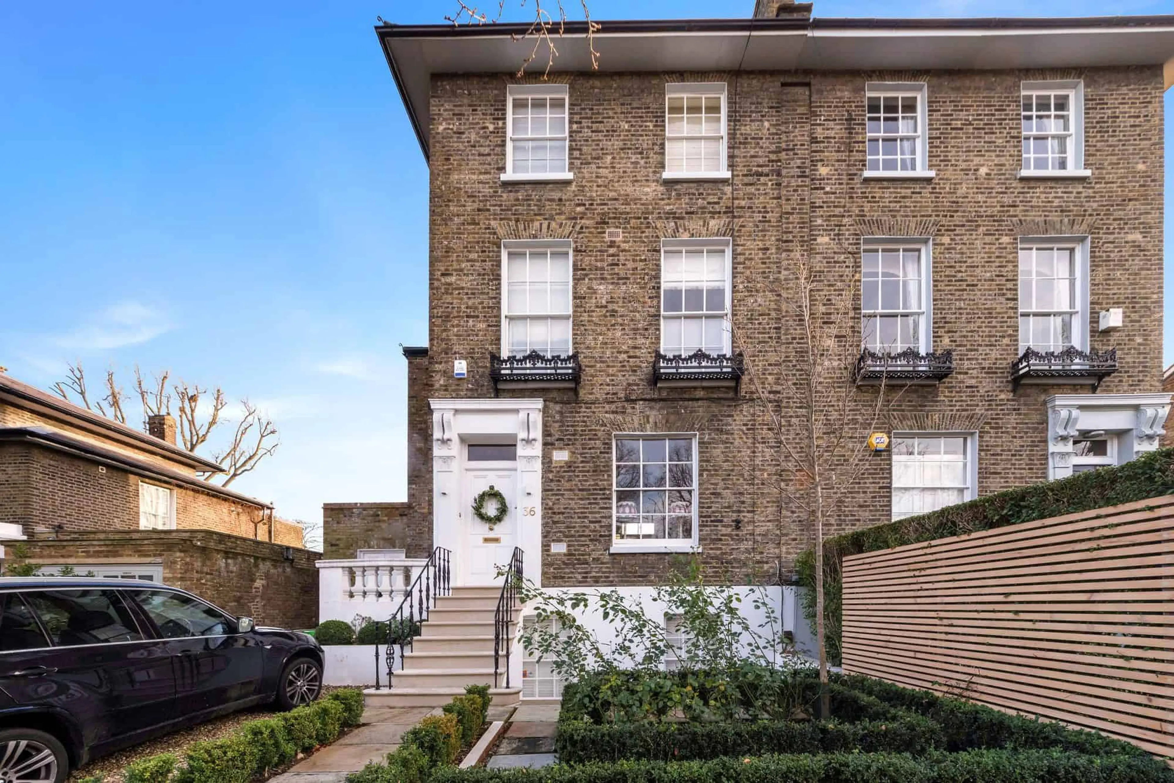 Georgian front elevation with sash windows, restored entrance steps and iron railings